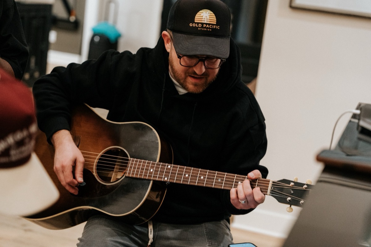 Landon playing an acoustic guitar during a session