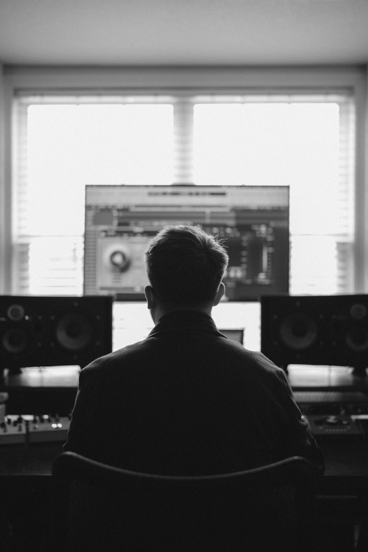 Landon at the mixing desk, framed by studio monitors and a bright window