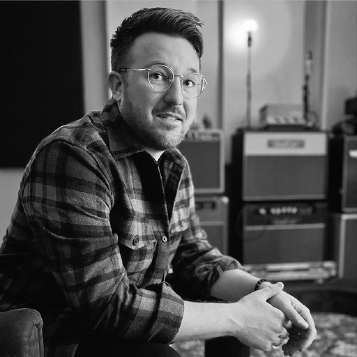 Portrait of Landon Bailey in the studio, amps stacked behind him